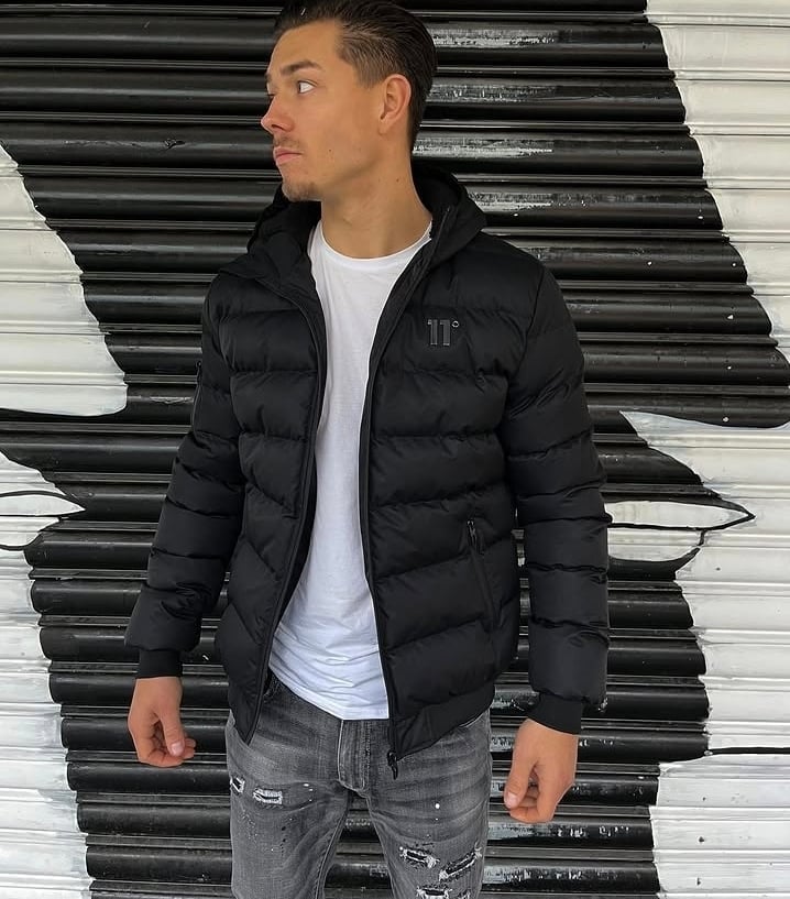 Man wearing black puffer jacket over ripped jeans