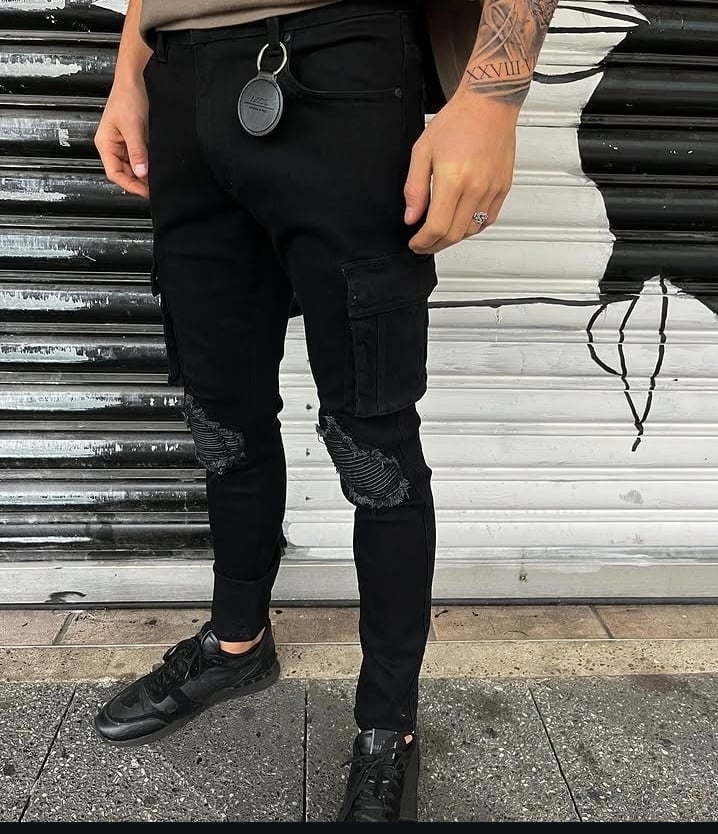 Person wearing black ripped jeans with chain wallet detail and black sneakers