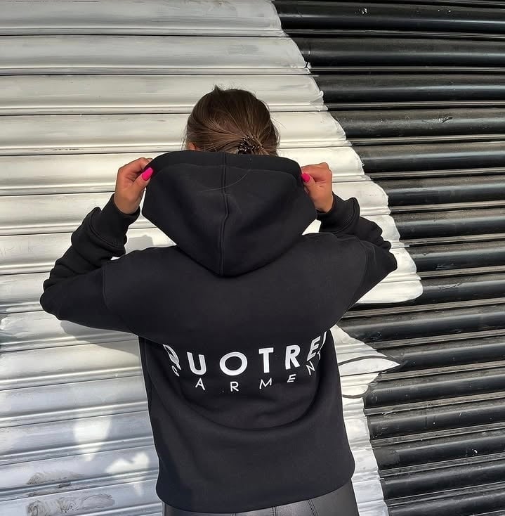Person wearing black hoodie with white text, view from behind